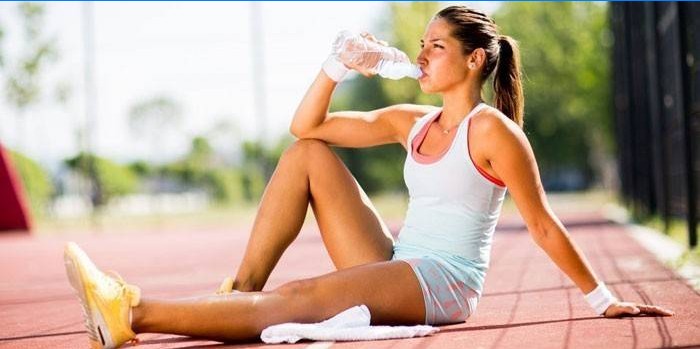 Fille boit de l'eau provenant d'une bouteille