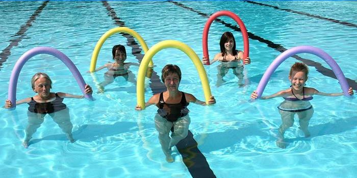 Cinq femmes avec des nouilles dans la piscine