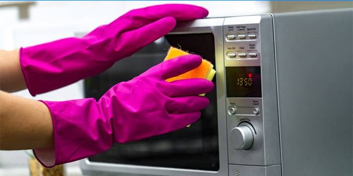 Femme lave un micro-ondes