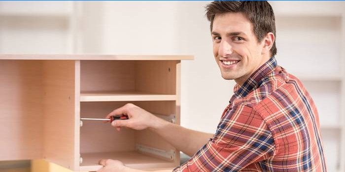 Un homme fixant une armoire