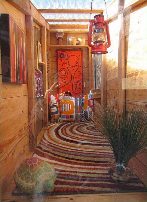Coussins de sol colorés dans une cabane en bois inhabituelle