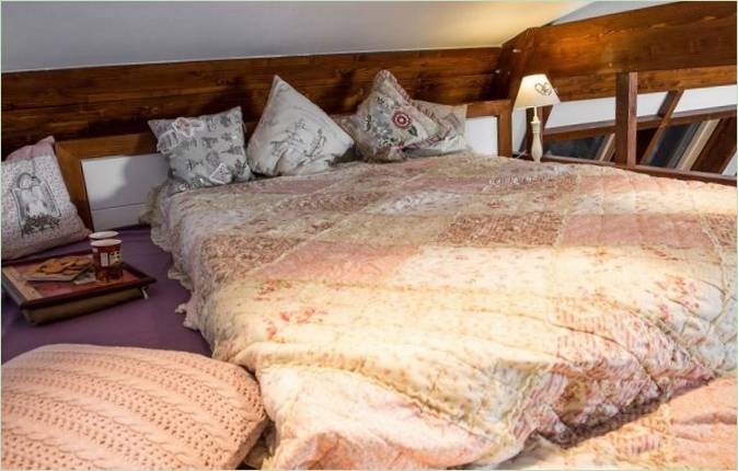 Un lit luxueux avec des coussins et un plaid de style romantique