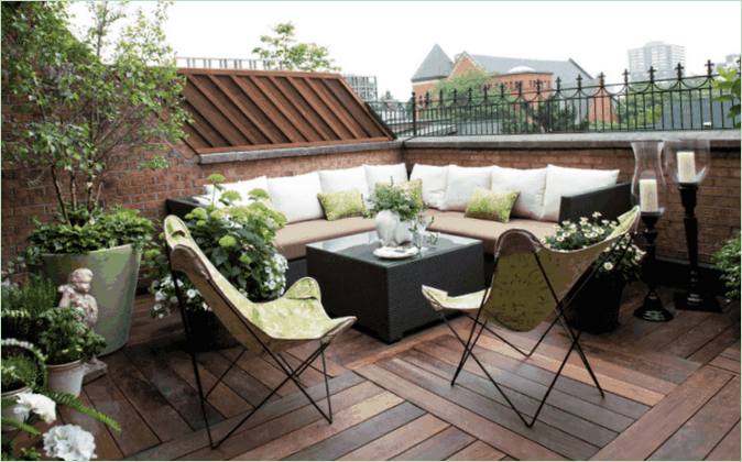 Terrasse rustique sur le toit - canapé d'angle, fauteuils et fleurs La terrasse sur le toit de la maison de campagne - canapé d'angle, fauteuils et fleurs