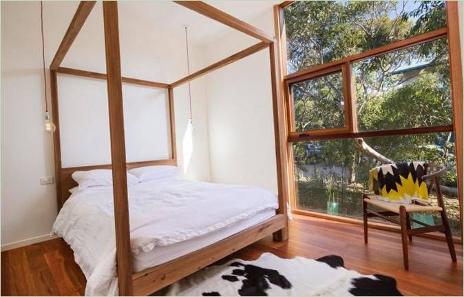 Intérieur d'une maison moderne en bois : fenêtre à châssis relevable dans la chambre à coucher