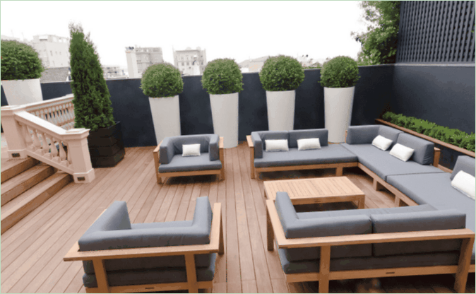 L'aménagement de la terrasse d'une maison de campagne - canapés gris n et plantes vertes Aménagement d'une terrasse de banlieue - canapés gris n et plantes vertes