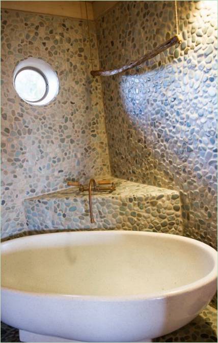 Un mur de baignoire orné de pierres de rivière