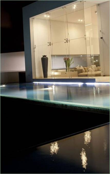 Piscine illuminée par les murs de verre d'un manoir
