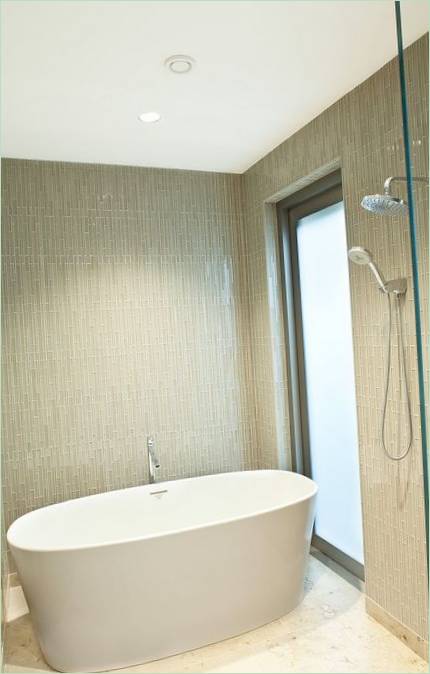 Une salle d'eau couleur pistache avec une baignoire blanche comme neige