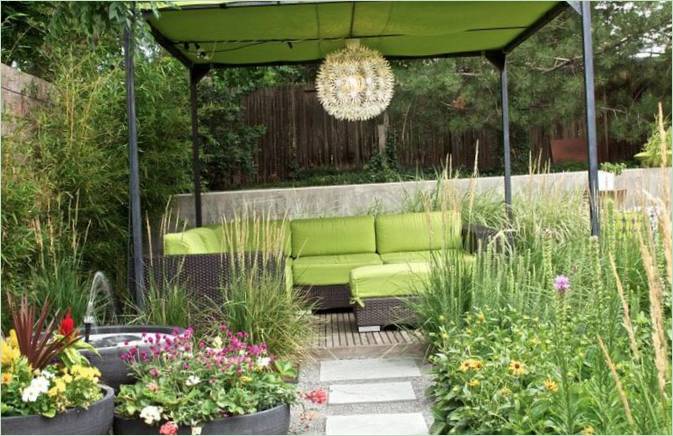 Aménagement paysager économique - herbes hautes, parterres de fleurs fermés et un auvent avec un canapé Aménagement paysager économique - herbes hautes, parterres de fleurs fermés et un auvent avec un canapé