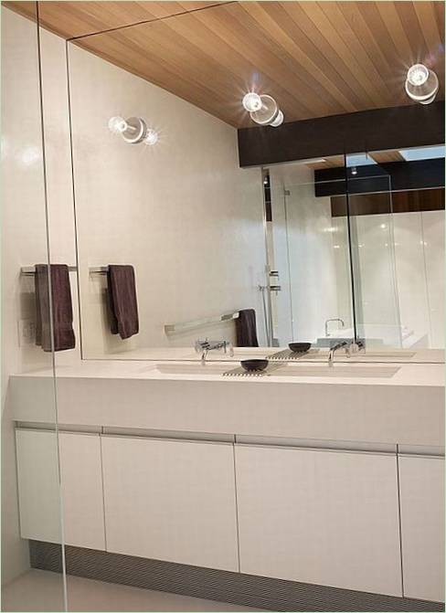 Plafond en bois et mur en miroir dans un intérieur de salle de bains blanche
