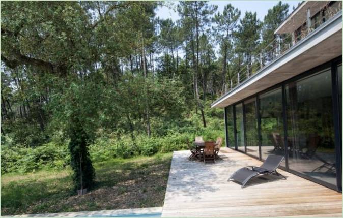 Une chaise longue et une table avec chaises sur la terrasse