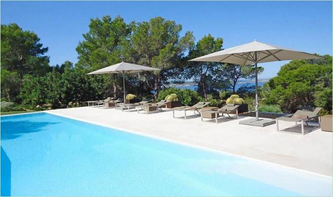 Chaises longues et parasols sur la terrasse de la piscine