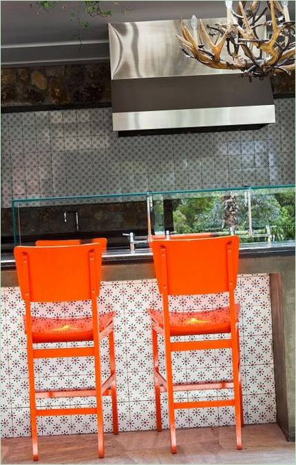Des chaises aux couleurs vives contre une cuisine noire : un contraste saisissant