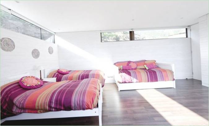 Combinaison originale de couleurs dans la chambre d'une maison côtière de LAND Arquitectos