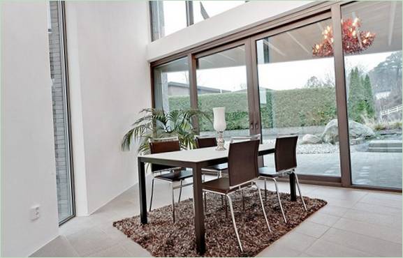 Salle à manger confortable donnant sur une haie dans un jardin fleuri