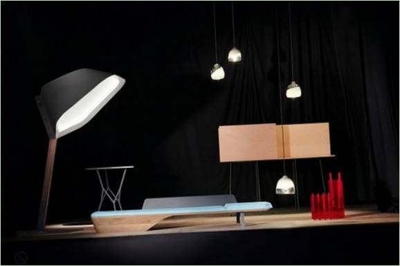 Une composition d'objets domestiques : une lampe de table, des lampes suspendues, une table aux pieds ajourés, un lit de repos en bois et un bureau