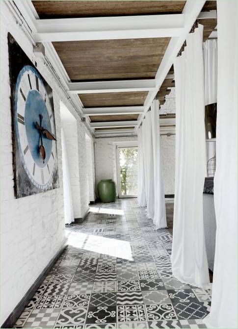 Des murs en briques blanches associés à des carreaux gris et noirs donnent à la pièce une impression de fraîcheur