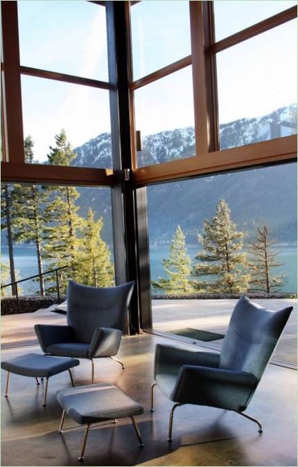 Sièges confortables dans le salon d'une maison au bord d'un lac de montagne par Johnston Architects