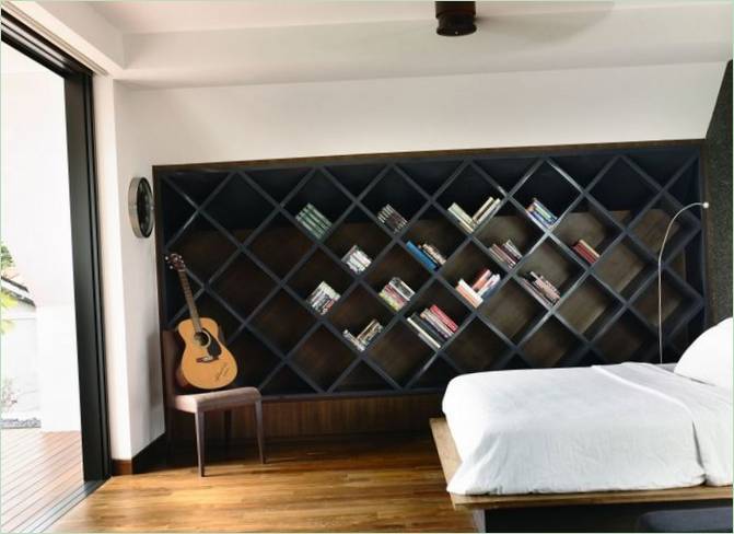 Aménagement d'une des chambres avec des étagères en forme de losange pour les livres