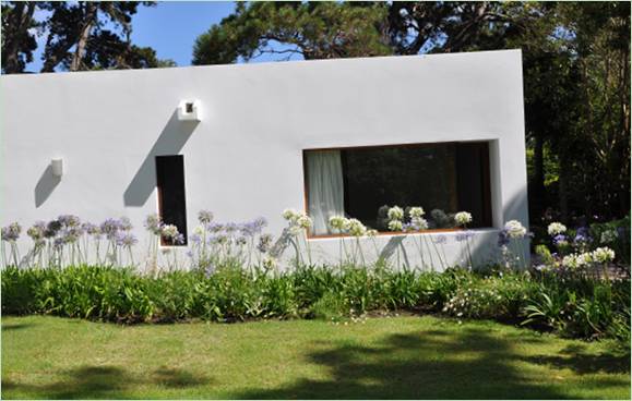 Casa La Hilaria en Uruguay, entourée de fleurs et d'arbres