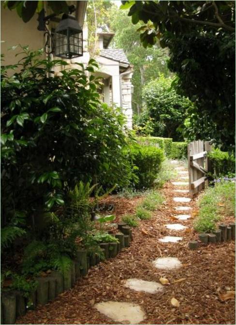 Un chemin en dalles de pierre entouré de feuillage dans le jardin