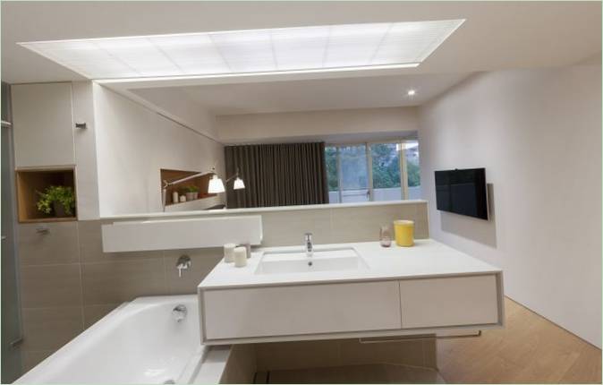 Baignoire rectangulaire et lavabo carré dans une salle de bains