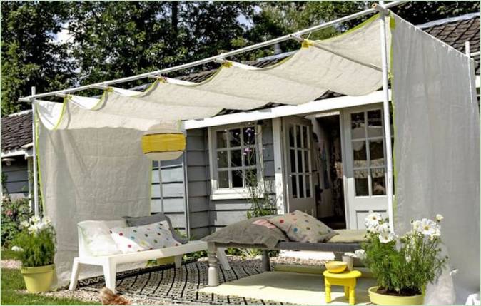 Espace salon dans le jardin sous un chapiteau improvisé