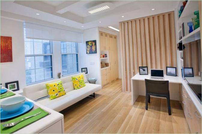 Un canapé blanc et des coussins lumineux dans la chambre à coucher
