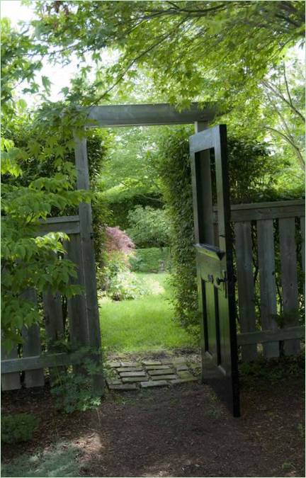 Un portillon en bois donnant accès au jardin