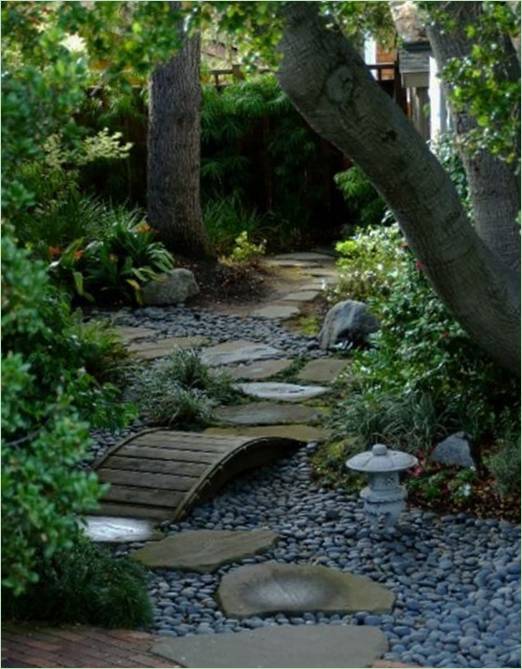 Pont en bois et chemin en pierre dans le jardin