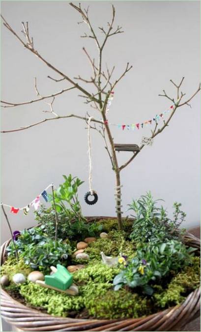 Une balançoire à cordes et une roue dans un mini jardin