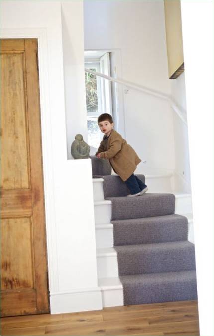 Escalier menant au premier étage avec moquette grise