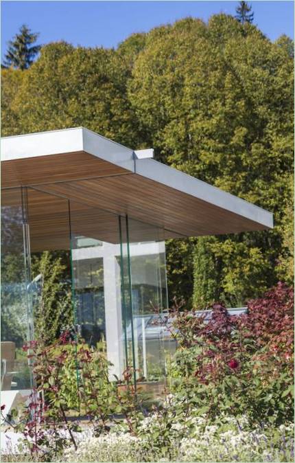 Gazebo au bord de la piscine entouré de verdure