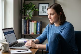 Jeune femme concentrée sur son ordinateur dans un bureau à domicile